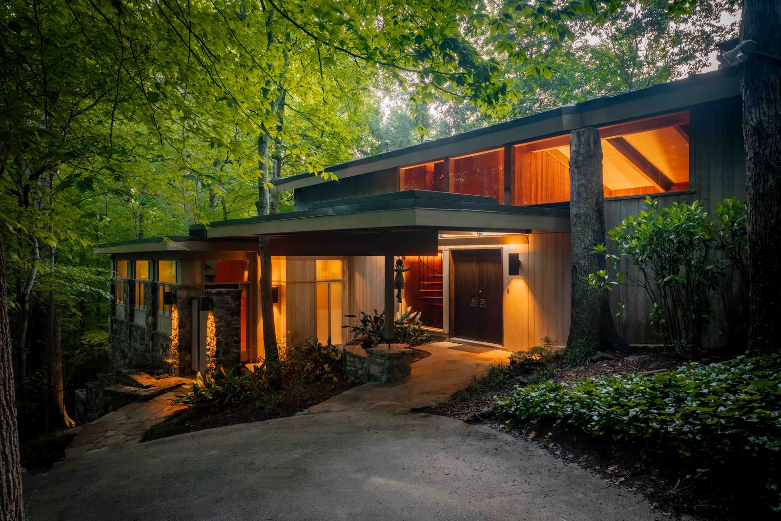 Architect Herbert Millkey designed the 1969 home with extensive wood paneling, stone walls, and balconies overlooking the surrounding forest.