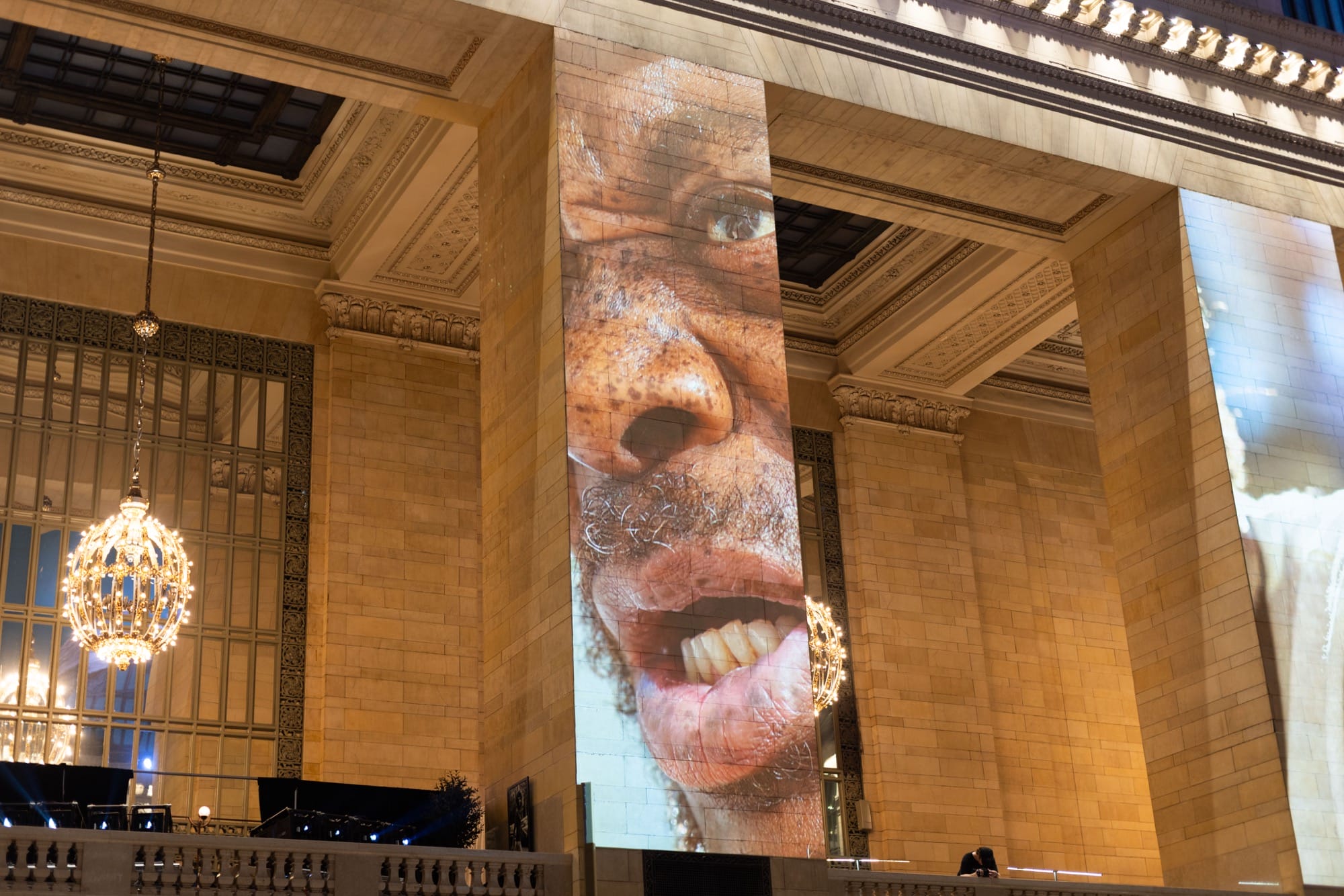 a photo installation of Brandon Stanton's Dear New York projected on the architecture of Grand Central Station