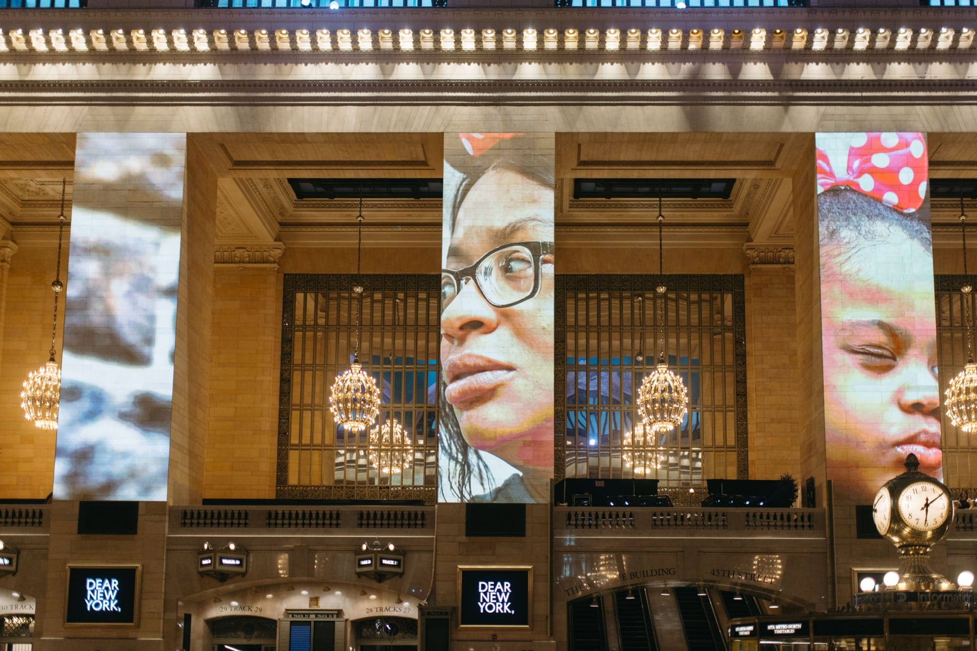 a photo installation of Brandon Stanton's Dear New York projected on the architecture of Grand Central Station