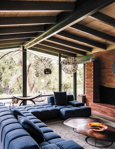 In the living room of the main house, a sofa by Patricia Urquiola surrounds a Nathan Young coffee table, capped with a floor lamp by Achille Castiglione.