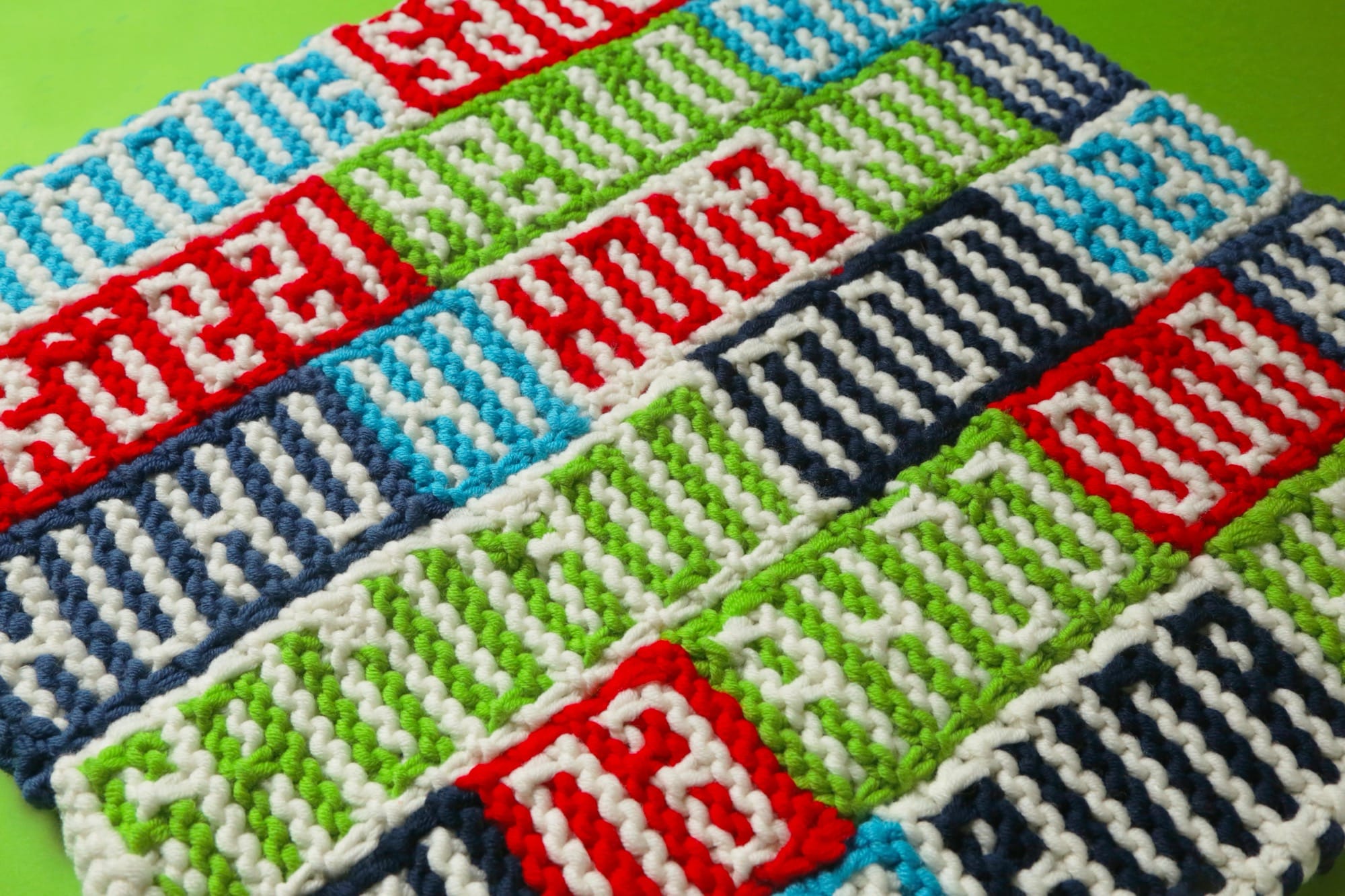 a knitted, patchworked fabric that read "HELLO" in different languages