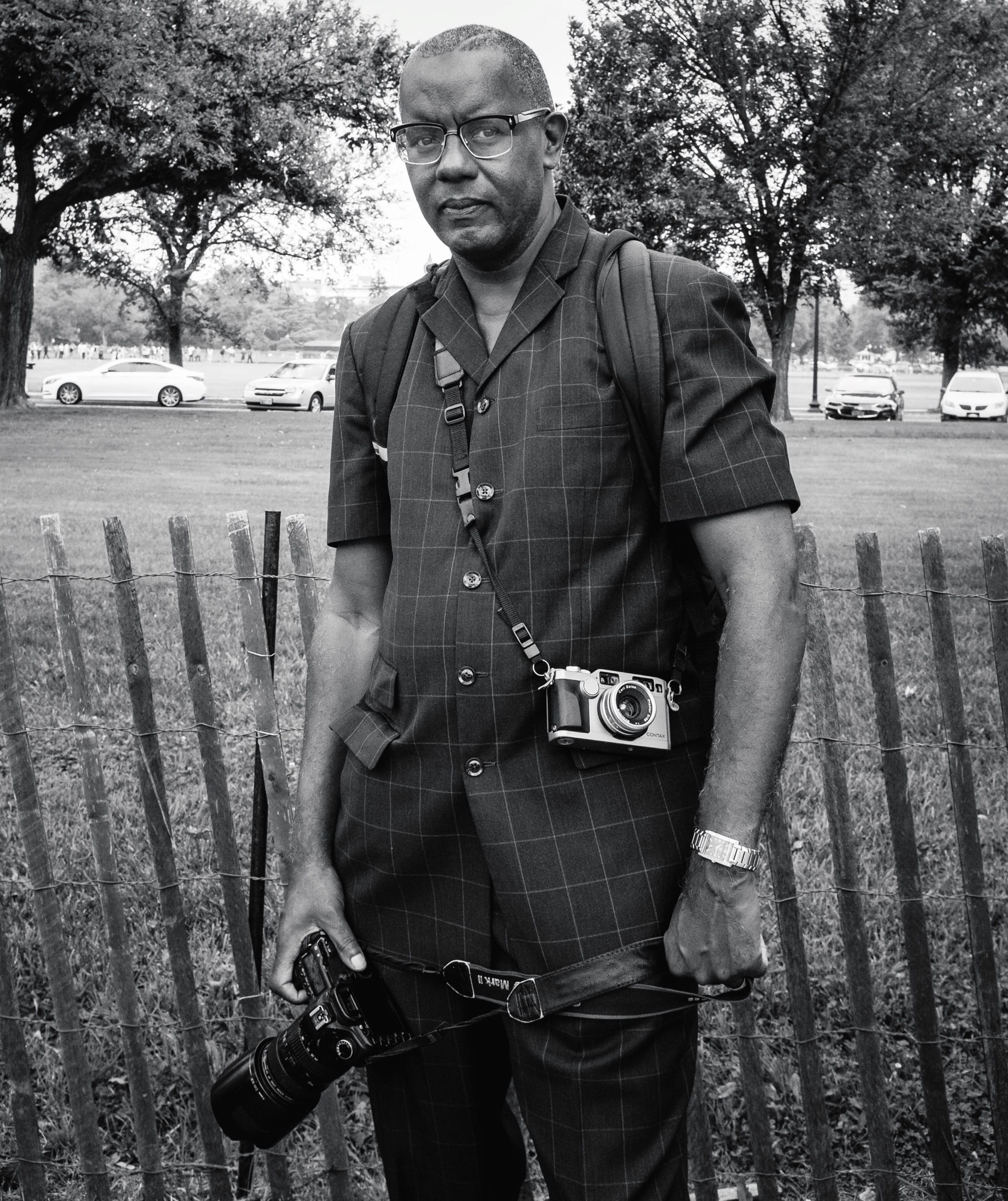 a black and white portrait of Jamel Shabbaz with his camera