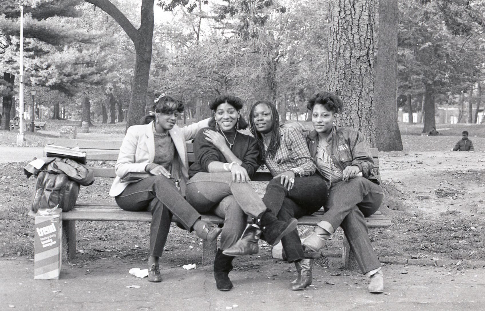 a photo by Jamel Shabbaz of a group of women sitting on a bench