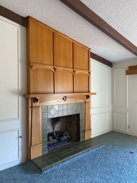 The original living room featured wall-to-wall carpeting and a popcorn ceiling.