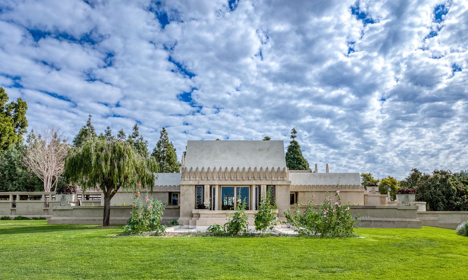The TK facade of the house. In contrast to Wright’s earlier Midwestern-inspired Prairie-style designs, the temple-like Hollyhock House was influenced by pre-Columbian architecture, notably Mayan and Aztec styles, though some have also described it as Asian or Egyptian. The result was something the architect called