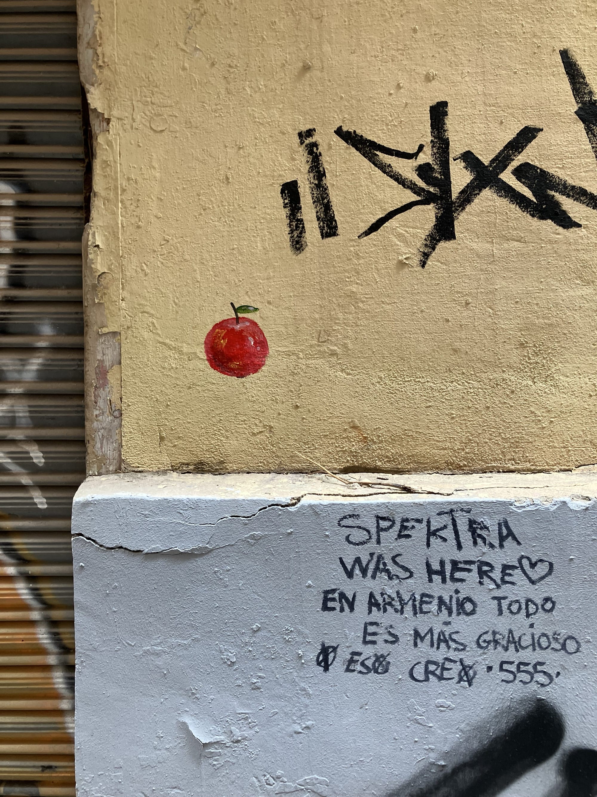 a small apple painted on a wall by escif