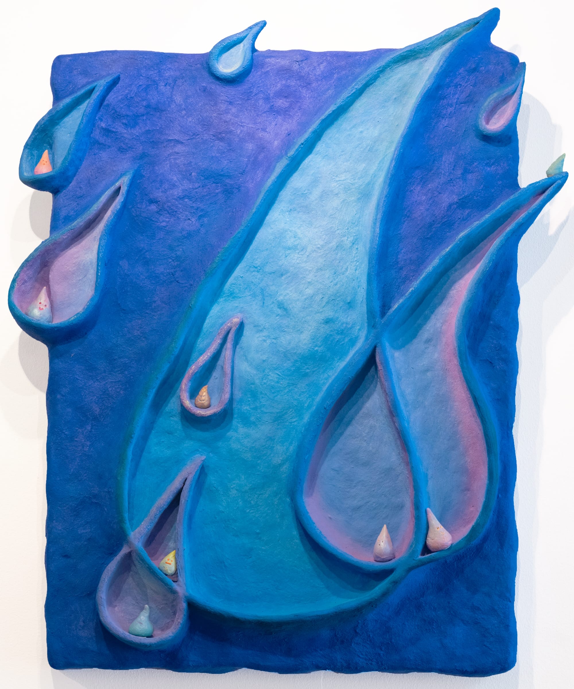 a sculptural relief in blues and purples by Yen Yen Chu of overlapping water droplets