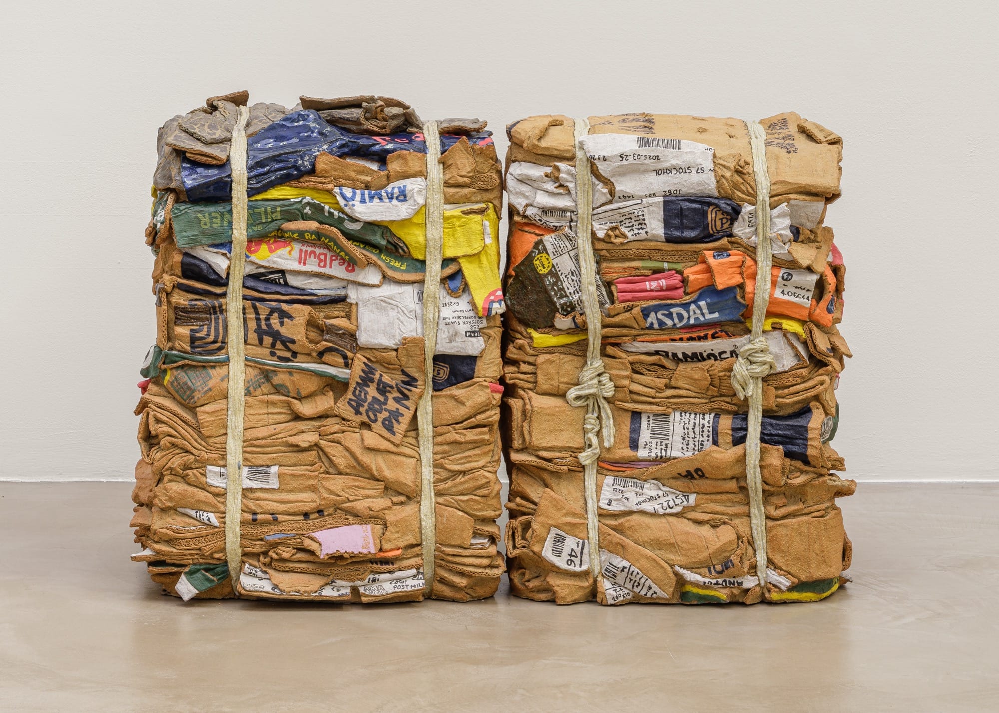 a sculpture by Ninon Hivert made of clay and other materials that mimics two compressed stacks of cardboard boxes