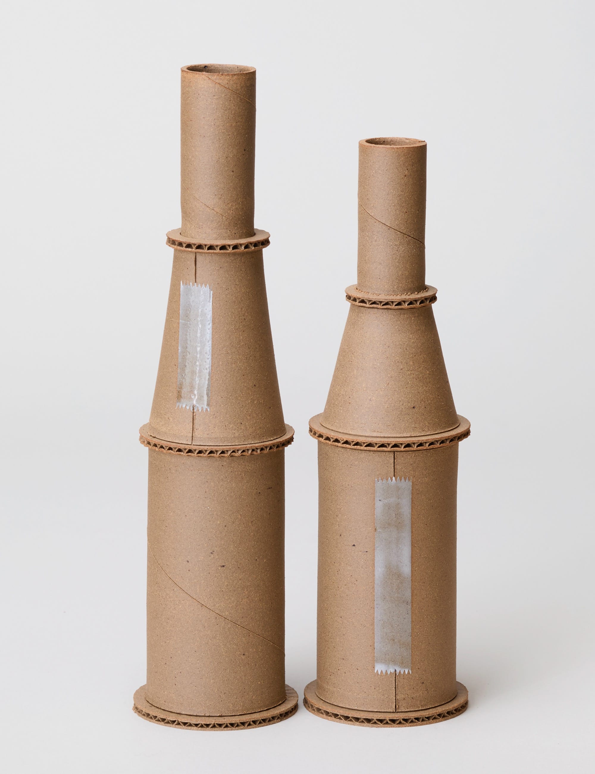 two ceramic vessels by Jacques Monneraud that resemble cardboard tubes with clear tape