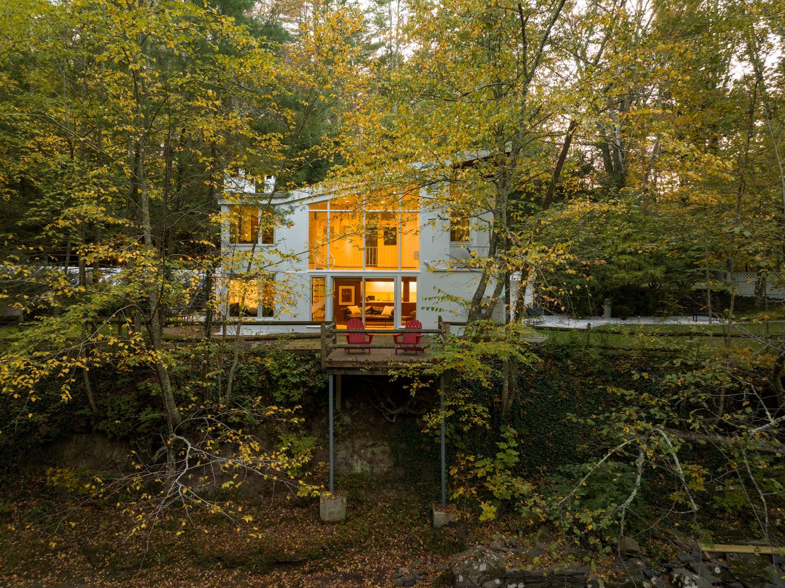 This Catskills home has ample outdoor space and double-height windows that frame big views of the surrounding forest.